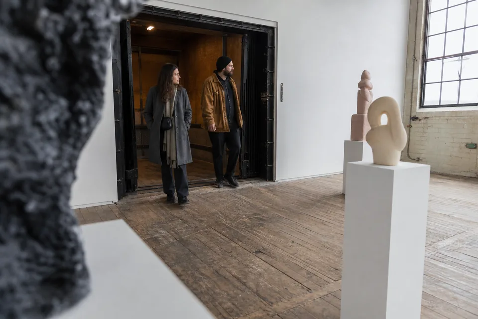 Visitors step out of a freight elevator into an upper floor gallery in a converted Chelsea warehouse