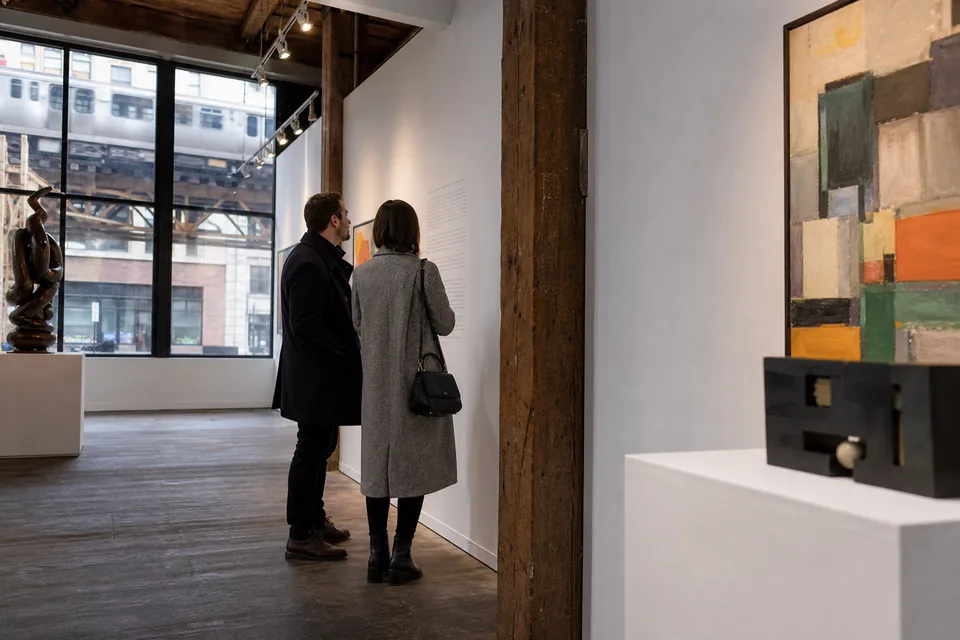 A loft gallery in a brick building with an elevated train passing outside the window